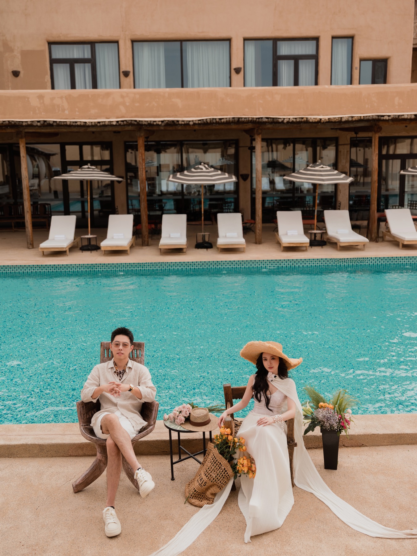 江也飞与罗可身着白色礼服坐在泳池边